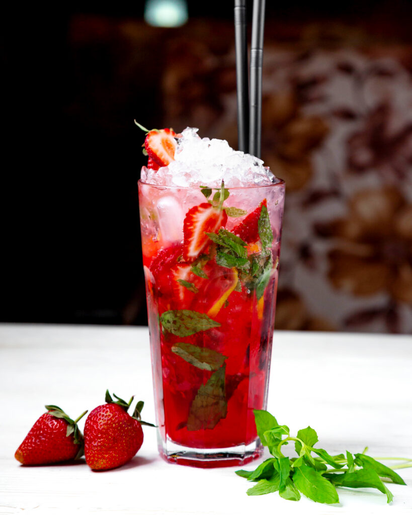 Mocktail fraises miel et lime servi dans un grand verre avec menthe fraîche et glaçons